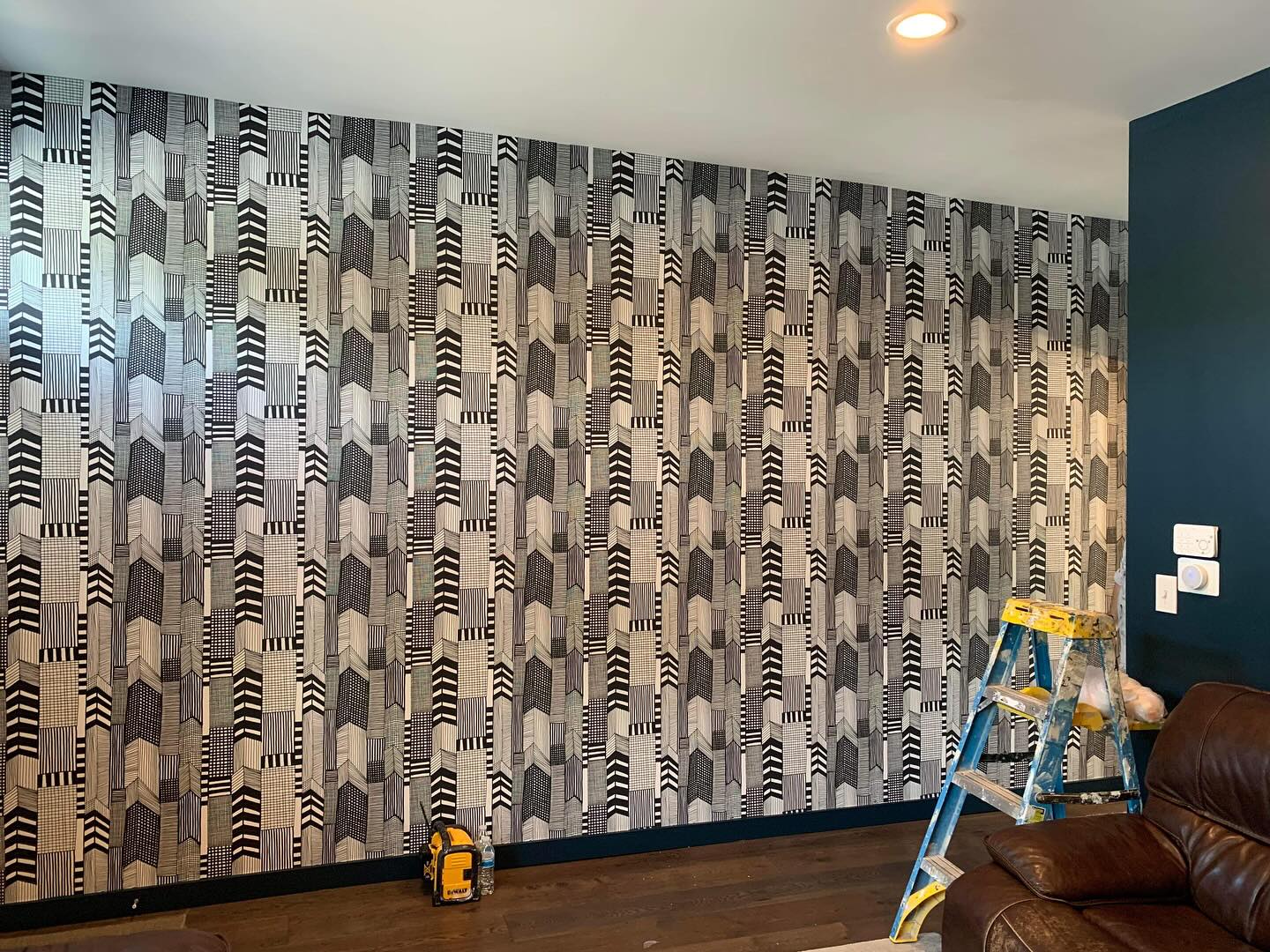 Finished patterned wall with wallpaper installation tools nearby